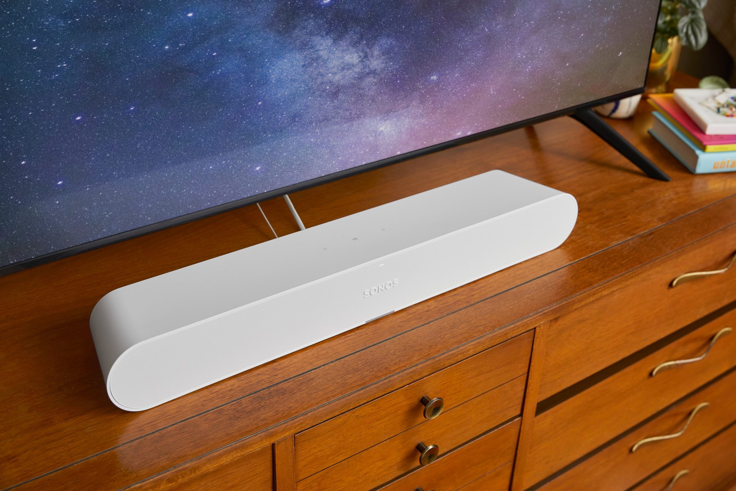 A white Sonos Ray on a credenza beneath a TV